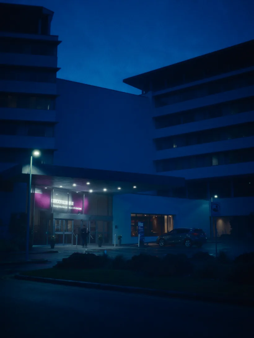 Car waiting at a hospital drop-off at dusk